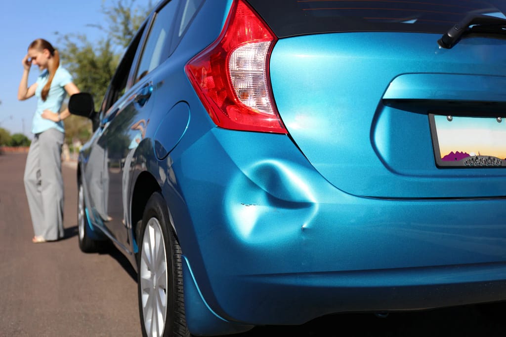Minor accident blue car dented bumper